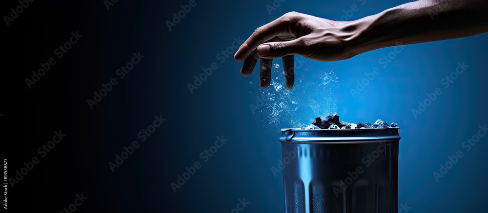 Poster a man s hand with a clipper discards it into a blue trash can. with copy space image. place for addi