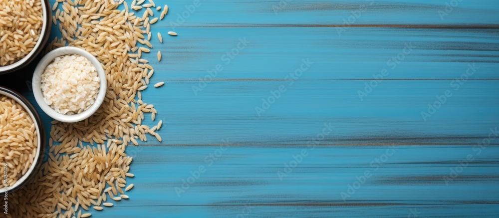 Aufkleber View from above of a cup containing both rice and buckwheat placed on a blue wooden surface creating an appealing copy space image