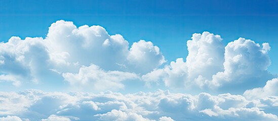 A copy space image of a clear blue sky adorned with fluffy white clouds