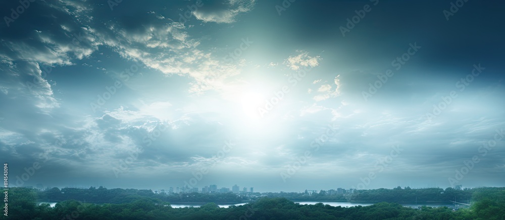 Aufkleber The cloudy sky is illuminated by a beam of light creating a picturesque backdrop with trees in the frame perfect for a copy space image