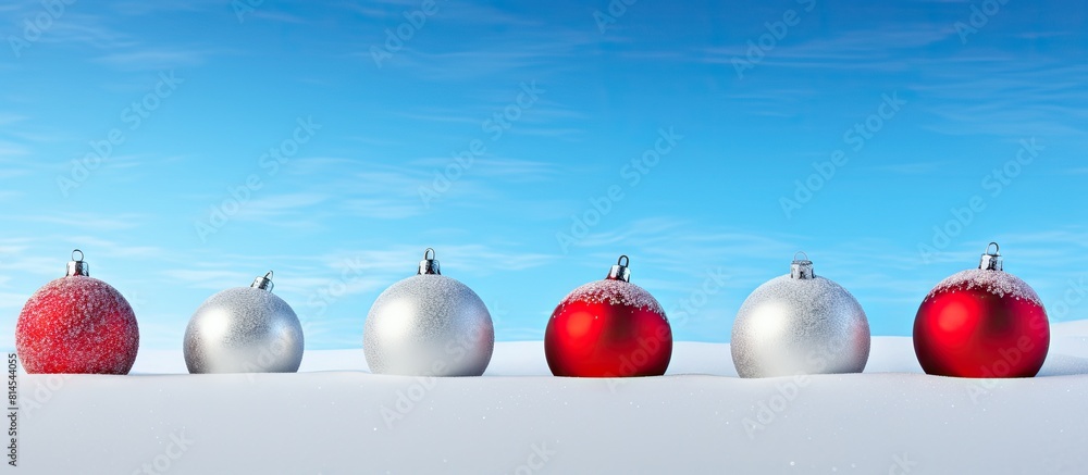 Poster a copy space image featuring isolated christmas colored balls on a snowy background representing the