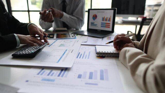 Meeting with business consulting partner is discussing analysis of financial reports and market share situation to plan strategy. Discussion of financial chart analysis to plan profit maximization.