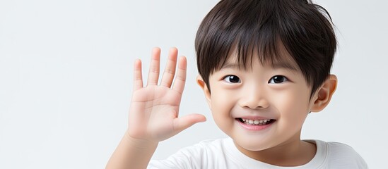 A happy and attractive Asian child showcasing an area for text or images on their open palm against a plain white backdrop. with copy space image. Place for adding text or design