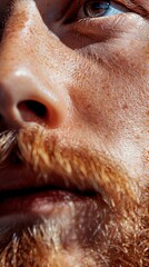 A close-up view of a mans face with a distinct moustache