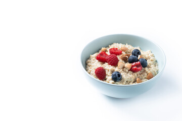 Oatmeal porridge with raspberries, blueberries and almonds in bowl isolated on white background. Copy space