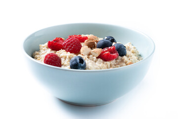 Oatmeal porridge with raspberries, blueberries and almonds in bowl isolated on white background
