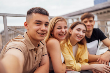 Obraz premium Four cute teenagers taking a selfie. Funny friends takes a picture of theyself