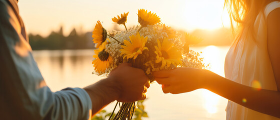 Person holds yellow and white flower bouquet under blue sky - Powered by Adobe