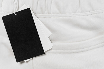 Close-up of a blank tag on white clothing. Resource for mockup design.