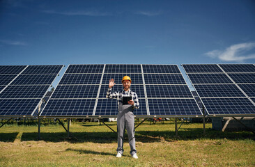 Engineer with photovoltaic solar panels outdoors at daytime