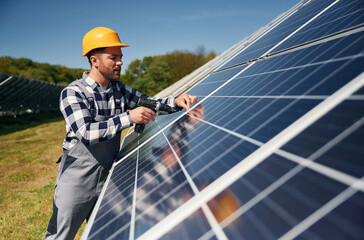 Checking the surface. Engineer with photovoltaic solar panels outdoors at daytime