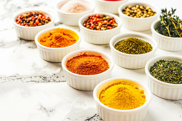 A selection of colorful spices, each one adding depth and flavor to culinary creations, arranged neatly on a white countertop.