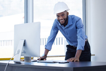 Portrait, engineer and black man in office, hard hat and computer with smile, career ambition and...