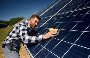 Surface must me clean. Engineer with photovoltaic solar panels outdoors at daytime