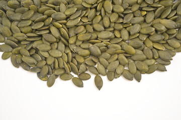 Photograph of a stack of hulled green pumpkin seeds without shell isolated on white background with copy space. Top view. 
