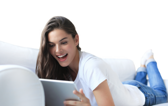 Beautiful young woman using tablet sitting on sofa at home on a transparent background