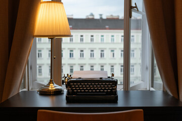 Workplace of a writer, journalist, creator. An old typewriter and a lamp on the table. Retro style. The concept on scientific, historical, literature, education and philosophical topics.