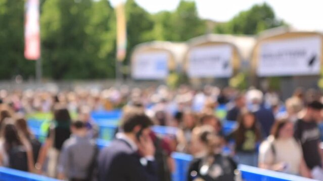 persone in coda che camminano in attesa di entrare ad un evento ,fiera ,ripresa larga
