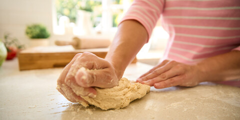 Close Up Of Woman At Home In Kitchen Making Dough On Worktop Or Counter