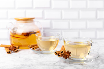 Fragrant hot tea with cinnamon stick and anise on a textured wooden background. A cup of hot tea...
