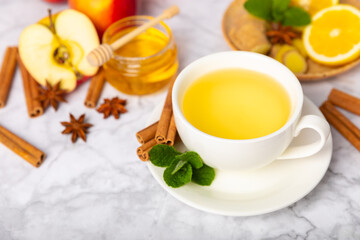 Fragrant hot tea with cinnamon stick and anise on a textured wooden background. A cup of hot tea...