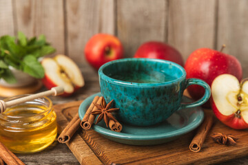 Fragrant hot tea with cinnamon stick and anise on a textured wooden background. A cup of hot tea...