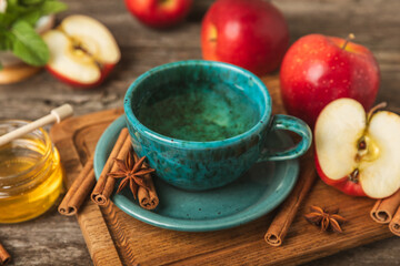 Fragrant hot tea with cinnamon stick and anise on a textured wooden background. A cup of hot tea...