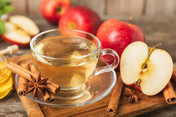 Fragrant hot tea with cinnamon stick and anise on a textured wooden background. A cup of hot tea...