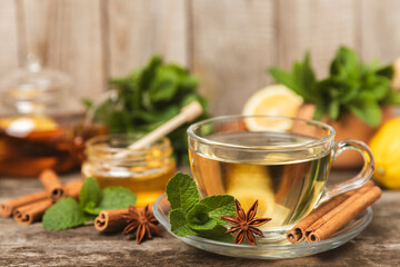 Fragrant hot tea with cinnamon stick and anise on a textured wooden background. A cup of hot tea...