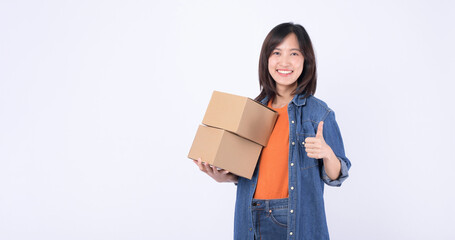 young asian woman wearing orange t-shirt and denim shirt holding parcel box isolated on white...