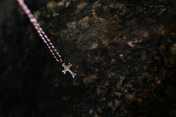 Traditional Armenian baptismal cross on a dark rocky surface