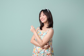 Happy Asian woman with casual dress isolated on pastel green background