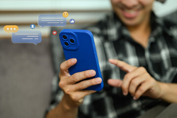 Smiling man chatting or text messages on his smartphone. Technology and communication concept