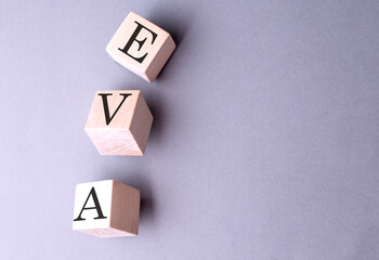 EVA word on wooden block on gray background