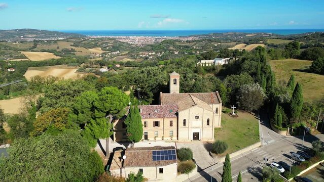 Ascending drone footage of parish church of Saint Stephan and nearby buildings in Candelara, Italy