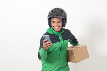 Portrait of Asian online courier driver wearing green jacket and helmet delivering package and box...