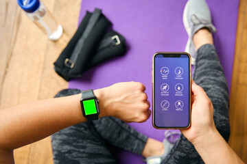 Close Up Of Woman With Smart Watch About To Exercise Looking At Health App On Mobile Phone