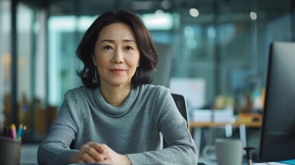 Chinese middle-aged female office co-worker, sitting at desk