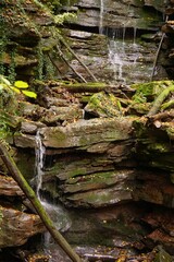 waterfall in green and yellows at the end of a canyon