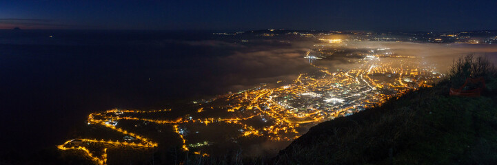 Panoramic view over the city at mediterranean coast from Monte Sant'Elia viewpoint during evening...
