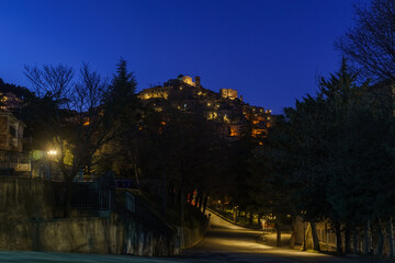Naklejka premium Night view after sunset at evening twilight of Morano Calabro during blue hour with yellow street lights. Province of Cosenza, Calabria, Italy