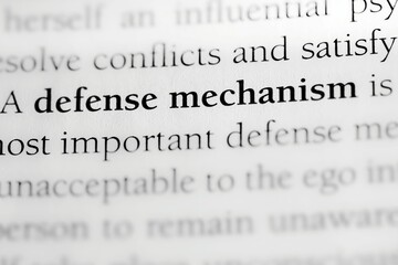Fototapeta premium Close-up of the Psychological coping term 'defense mechanism' printed in black on white paper