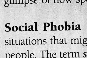 Closeup of a term for a psychological disorder 'social phobia' on white paper with black text