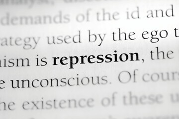 Close-up of the psychological defense mechanism term 'Repression' printed in black on white paper