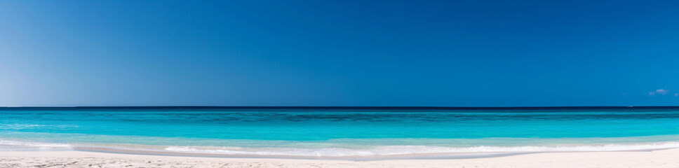 Unspoiled and tranquil pristine tropical beach panorama with white sand and turquoise water. Creating a serene and idyllic vacation travel background. Showcasing the clear water. Wide view