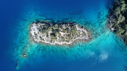 a small boat traveling through an island with blue water and green trees