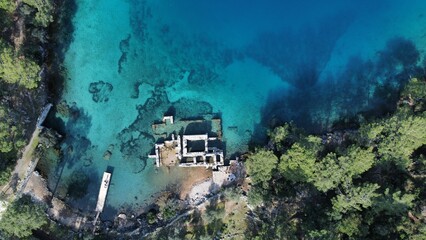 an aerial shot of a tropical island and boat dock, taken from above
