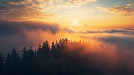 Obraz premium Sunrise above misty forest with glowing orange clouds