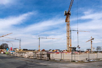 Start of construction of a concrete residential building. Construction cranes against a cloudy sky.