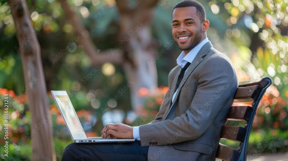 Poster a man in casual attire sitting on a bench outdoors, engaged with a laptop computer. he appears focus